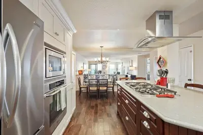 a kitchen with a refrigerator and a stove top oven at SurfSong Dream - Beachfront in Solana Beach