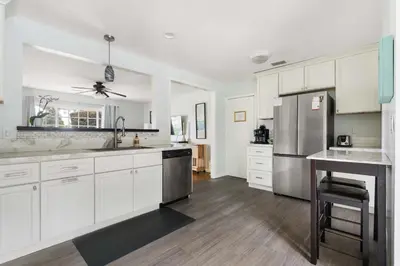 a kitchen with white cabinets and stainless steel appliances at O-Side Beach Bungalow with Jaccuzi Blocks to beach in Oceanside
