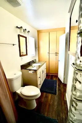 a bathroom with a white toilet and a sink at La Casita Poolside Retreat in Lake Elsinore