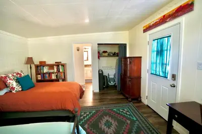 a bedroom with a bed with an orange blanket at La Casita Poolside Retreat in Lake Elsinore