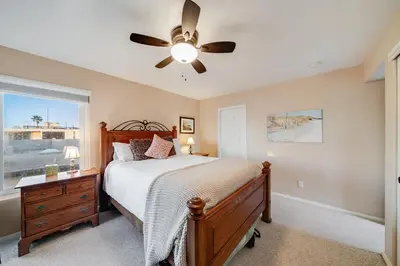 a bedroom with a bed and a ceiling fan at Navigate Stays Front Row to Paradise in San Diego