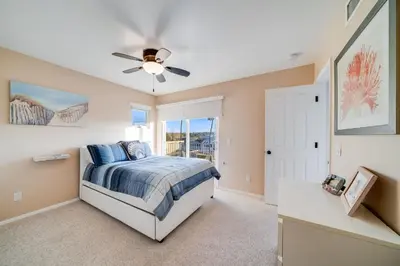 a bedroom with a bed and a ceiling fan at Navigate Stays Front Row to Paradise in San Diego