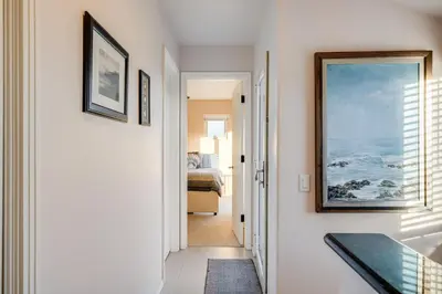 a hallway with a painting on the wall and a bedroom at Navigate Stays Front Row to Paradise in San Diego