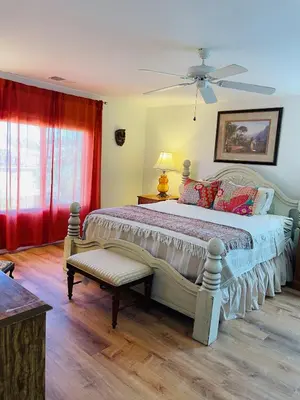 a bedroom with a large bed and a red curtain at 4Bd Spacious Oasis near wineries in Menifee