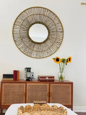 a mirror on a wall above a table with a vase of flowers at 4Bd Spacious Oasis near wineries in Menifee