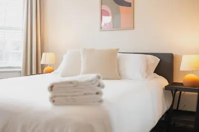 a bedroom with a bed with white sheets and two lamps at Outsite San Diego - Golden Hill in San Diego