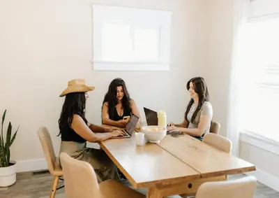 three women sitting around a table with their laptops at Outsite San Diego - Golden Hill in San Diego