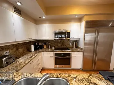 a kitchen with white cabinets and stainless steel appliances at Luxurious and Spacious 2-Bedroom Condo Unit Downtown San Diego in the Heart of the Gaslamp Quarter - 14-Day Min in San Diego