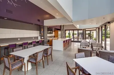 a restaurant with white tables and chairs and windows at Luxurious and Spacious 2-Bedroom Condo Unit Downtown San Diego in the Heart of the Gaslamp Quarter - 14-Day Min in San Diego
