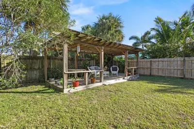 a wooden gazebo in a yard with a fence at Ocean Song in San Diego