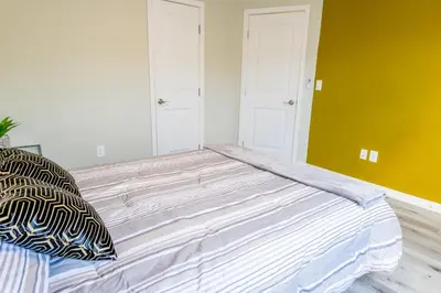 a large bed in a room with yellow walls at 2BR Retreat Near Balboa Park in San Diego