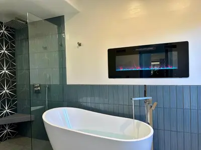 a bath tub in a bathroom with a tv on the wall at Hilltop Villa & Guesthouse, Pool Oasis, Pickleball Court in Fallbrook