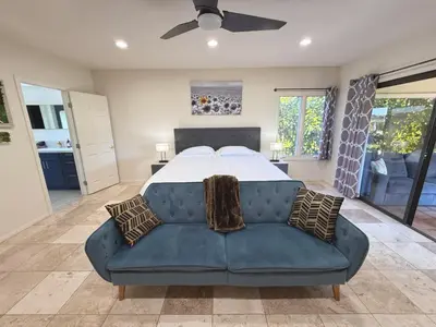 a bedroom with a large bed with a blue couch at Hilltop Villa & Guesthouse, Pool Oasis, Pickleball Court in Fallbrook