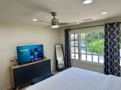 a bedroom with a bed and a flat screen tv at Hilltop Villa & Guesthouse, Pool Oasis, Pickleball Court in Fallbrook