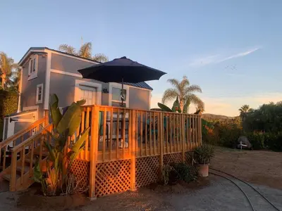 a house with a porch with an umbrella at Tiny House on private large property in Vista
