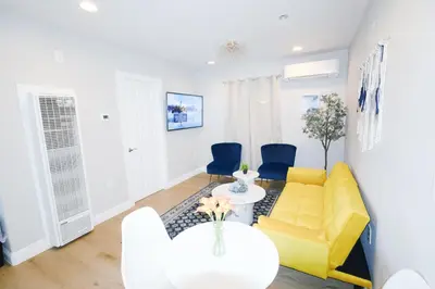 a living room with a yellow couch and blue chairs at Exotic home Rogers road in Spring Valley