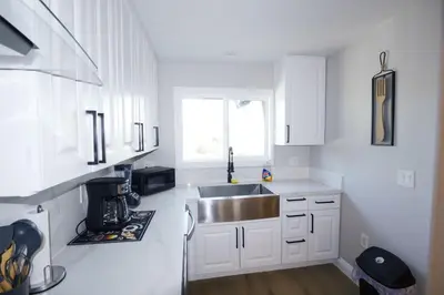 a kitchen with white cabinets and a sink at Exotic home Rogers road in Spring Valley