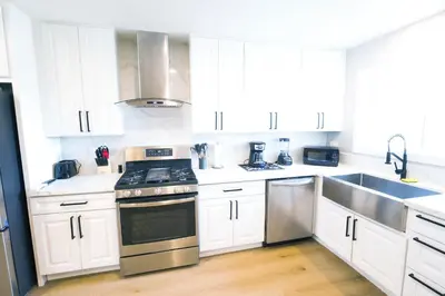 a kitchen with white cabinets and stainless steel appliances at Exotic home Rogers road in Spring Valley