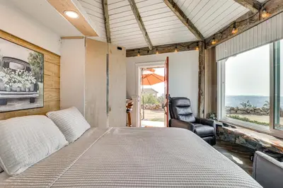 a bedroom with a bed and a chair and a window at Backyard and Zen Garden Hilltop Haven in Bonsall! in Vista