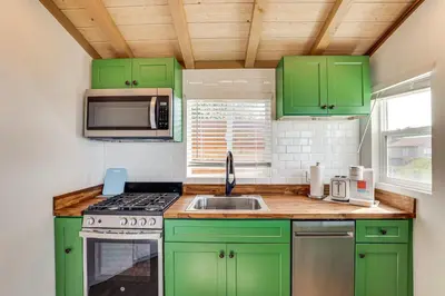 a kitchen with green cabinets and a sink at Backyard and Zen Garden Hilltop Haven in Bonsall! in Vista