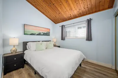 a bedroom with a white bed and a window at 3BR Home Steps from Shops, Pier and Beach in Newport Beach