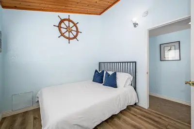 a bedroom with a white bed with a wooden ceiling at 3BR Home Steps from Shops, Pier and Beach in Newport Beach