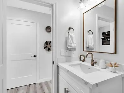 a white bathroom with a sink and a mirror at The Quaint Cardiff Hideaway with Pak N Play in Encinitas
