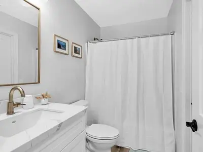 a white bathroom with a toilet and a sink at The Quaint Cardiff Hideaway with Pak N Play in Encinitas