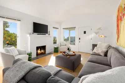 a living room with a couch and a fireplace at ENC-1035 - Charming Coastal Cottage in Encinitas