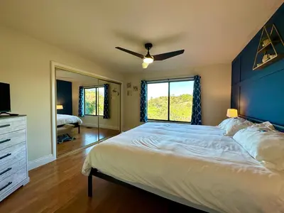 a bedroom with a large bed with a ceiling fan at Hilltop Penthouse Cottage with Sweeping Views in Fallbrook