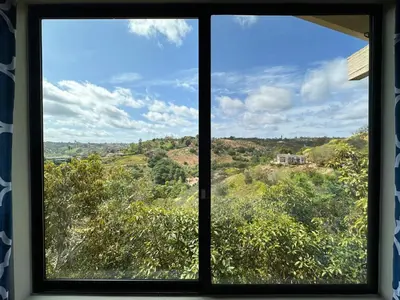 a window with a view of the countryside seen through it at Hilltop Penthouse Cottage with Sweeping Views in Fallbrook