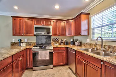 a kitchen with wooden cabinets and a stove and a sink at Hutchison Estate, Guest Suite 1 in Murrieta