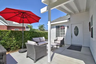 a patio with a red umbrella and chairs at Hutchison Estate, Guest Suite 1 in Murrieta