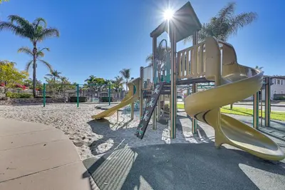 a playground with slides in a park with palm trees at Private and Spacious Deluxe Rolling Hills Ranch Gem in Chula Vista