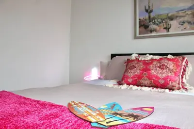 two flip flops on a bed with a pink blanket at Sol di Vito in San Diego