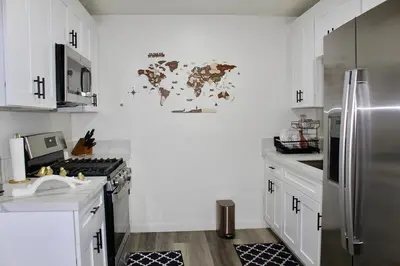 a kitchen with white cabinets and a stainless steel refrigerator at Sol di Vito in San Diego