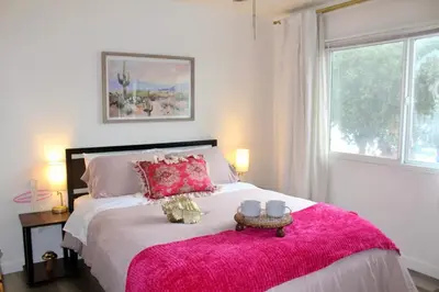 a bedroom with a large bed with a pink blanket at Sol di Vito in San Diego