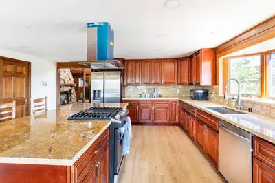 a kitchen with wooden cabinets and a stove top oven at San Diego Getaway, Views Pool Hot Tub & Game Room in Valley Center