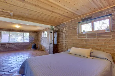 a bedroom with a bed in a brick wall at 4 Mi to Lake Wohlford Cabin in Escondido in Valley Center