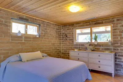 a bedroom with a bed and a brick wall at 4 Mi to Lake Wohlford Cabin in Escondido in Valley Center