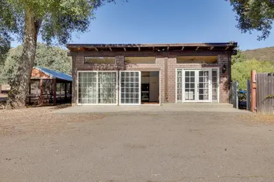 a brick building with a large window and a tree at 5 Mi to Casino and Lake Home on Escondido Ranch! in Valley Center
