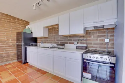 a kitchen with white appliances and a brick wall at 5 Mi to Casino and Lake Home on Escondido Ranch! in Valley Center