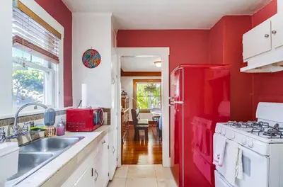 a red kitchen with a sink and a red refrigerator at Sunny San Diego Golden Hill Home! Pet Friendly, near DT, Fully Stocked! in San Diego