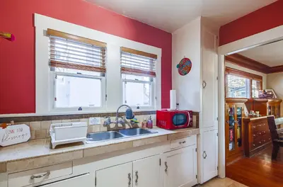 a kitchen with a sink and a red wall at Sunny San Diego Golden Hill Home! Pet Friendly, near DT, Fully Stocked! in San Diego