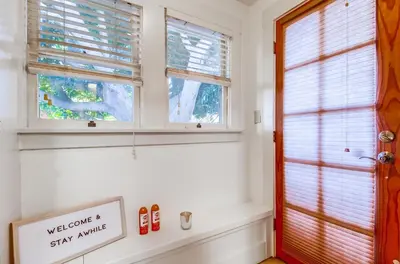 a bathroom with two windows and a sign that says welcome to stay awhile at Sunny San Diego Golden Hill Home! Pet Friendly, near DT, Fully Stocked! in San Diego