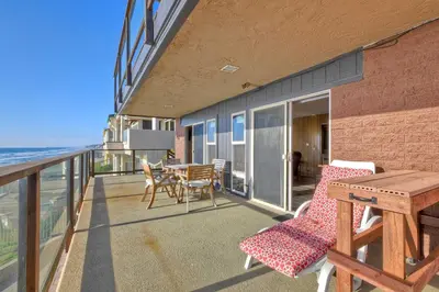 a balcony with a table and chairs and the ocean at Oceanfront Getaway - Ocean Views - Fire Pit - BBQ - Beach Access in Carlsbad