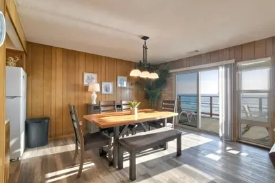a dining room with a wooden table and chairs at Oceanfront Getaway - Ocean Views - Fire Pit - BBQ - Beach Access in Carlsbad