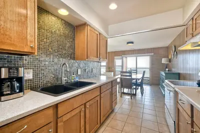 a kitchen with wooden cabinets and a sink at Oceanfront Getaway - Ocean Views - Fire Pit - BBQ - Beach Access in Carlsbad
