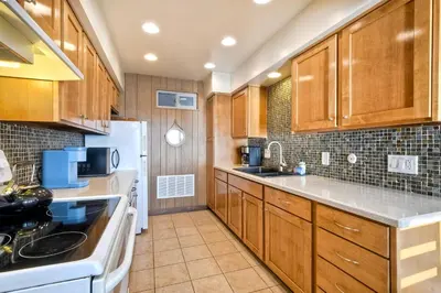 a kitchen with wooden cabinets and white appliances at Oceanfront Getaway - Ocean Views - Fire Pit - BBQ - Beach Access in Carlsbad
