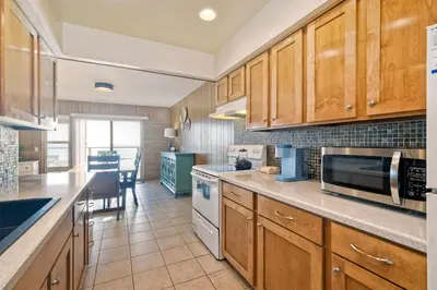 a kitchen with wooden cabinets and a counter top at Oceanfront Getaway - Ocean Views - Fire Pit - BBQ - Beach Access in Carlsbad